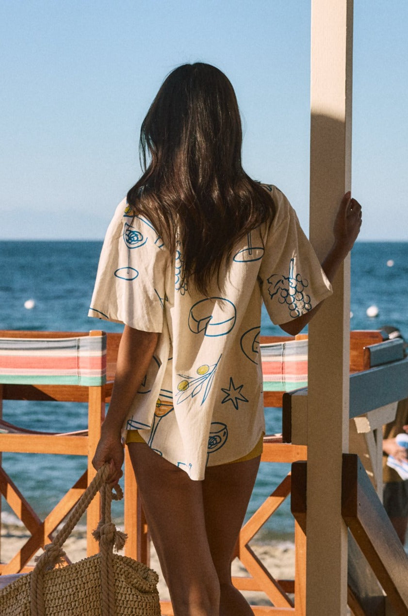 Printed woven shirt. Collar neckline. Short sleeves. Front button down closures. Front pocket. Unlined. shirt with wine on it. shirt with lemon. shirt with grapes. beach cover up. beack top cover up. summer top. vacation top. vacation outfit. european summer top. european summer outfit. european summer outfit inspo