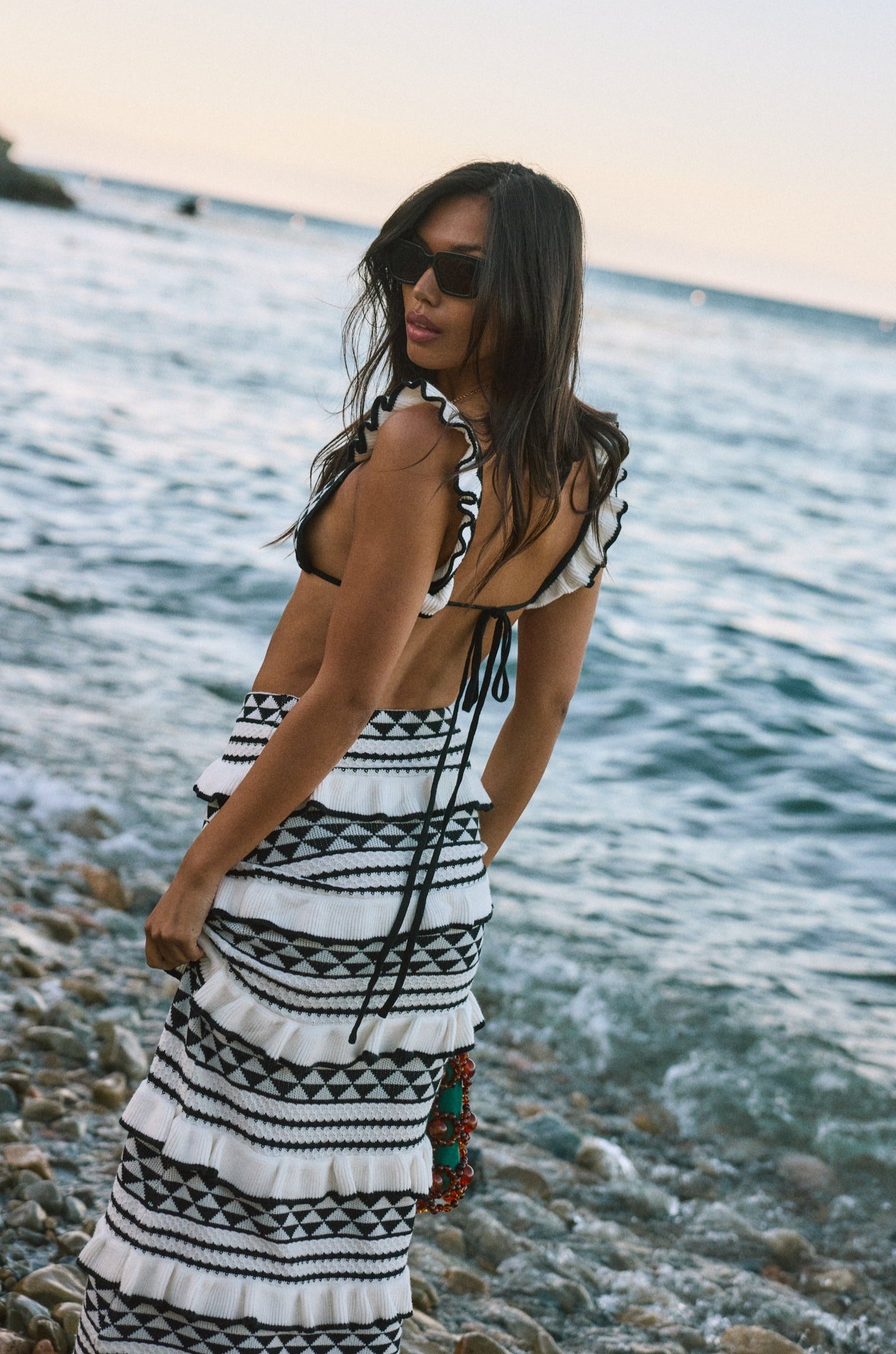 Crochet knit bikini top. Ruffle trim. Adjustable back tie closure. Crochet knit maxi skirt. Elastic waist. Ruffle trim. Unlined. black and white set. black and white skirt set. skirt and crop top set. summer outfit. summer going out set. beach vacation outfit. fancy dinner outfit. european summer outfit. european summer set. european summer outfit inspo. vacation outfit