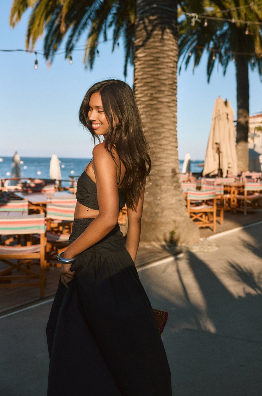 Woven maxi skirt. Ruched details. Side hook and eye and zipper closures. Side pockets. Unlined. summer outfit. summer going out skirt. beach vacation outfit. beach vacation skirt. fancy dinner skirt. european summer outfit. european summer skirt. european summer outfit inspo. vacation outfit. black skirt and cropped tank set