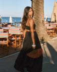 Woven maxi skirt. Ruched details. Side hook and eye and zipper closures. Side pockets. Unlined. summer outfit. summer going out skirt. beach vacation outfit. beach vacation skirt. fancy dinner skirt. european summer outfit. european summer skirt. european summer outfit inspo. vacation outfit. black skirt and cropped tank set