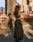 Woven maxi skirt. Ruched details. Side hook and eye and zipper closures. Side pockets. Unlined. summer outfit. summer going out skirt. beach vacation outfit. beach vacation skirt. fancy dinner skirt. european summer outfit. european summer skirt. european summer outfit inspo. vacation outfit. black skirt and cropped tank set