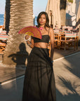 Woven maxi skirt. Ruched details. Side hook and eye and zipper closures. Side pockets. Unlined. summer outfit. summer going out skirt. beach vacation outfit. beach vacation skirt. fancy dinner skirt. european summer outfit. european summer skirt. european summer outfit inspo. vacation outfit. black skirt and cropped tank set