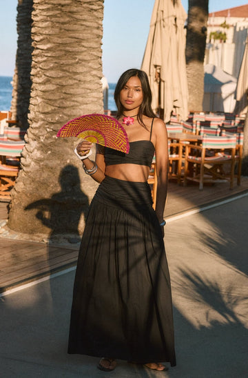 Woven maxi skirt. Ruched details. Side hook and eye and zipper closures. Side pockets. Unlined. summer outfit. summer going out skirt. beach vacation outfit. beach vacation skirt. fancy dinner skirt. european summer outfit. european summer skirt. european summer outfit inspo. vacation outfit. black skirt and cropped tank set