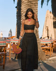 Woven maxi skirt. Ruched details. Side hook and eye and zipper closures. Side pockets. Unlined. summer outfit. summer going out skirt. beach vacation outfit. beach vacation skirt. fancy dinner skirt. european summer outfit. european summer skirt. european summer outfit inspo. vacation outfit. black skirt and cropped tank set