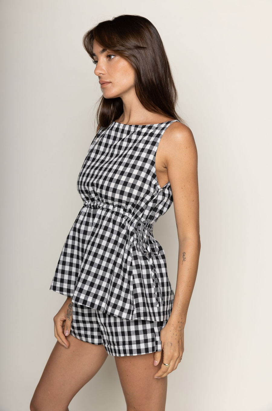 TOP:
Gingham printed flowy tank top
Ruched side ties
Back button closure
Unlined
Length: 21"
Cotton

BOTTOM:
Gingham printed shorts
Elastic waistband
Unlined
Length: 11.5"
Cotton

black and white gingham printed short set
summer set
