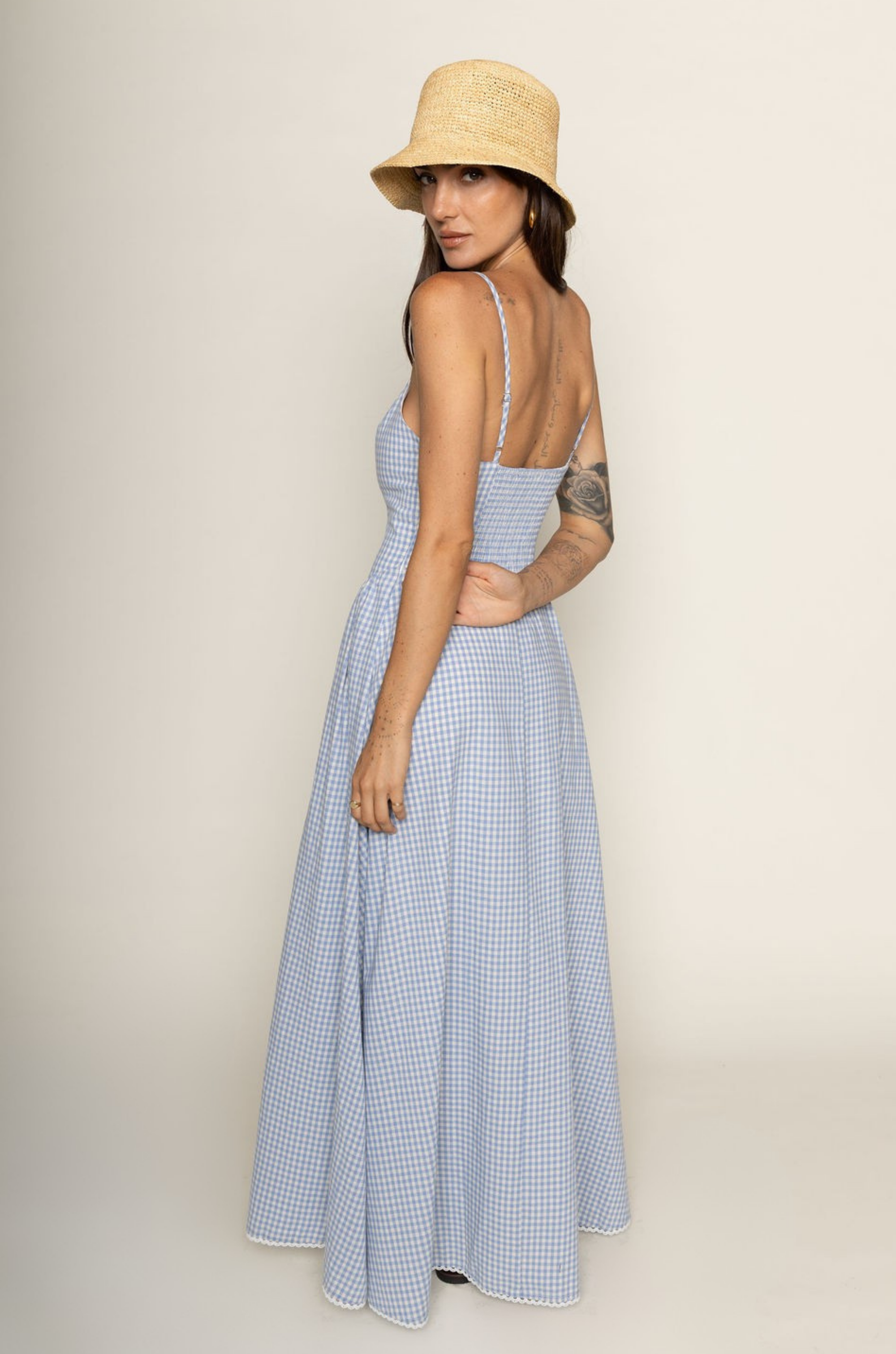 Woman wearing a blue checkered dress and straw hat on a beige backgroundBlue and white Checkered vintage maxi dress
V-neck neckline
Front button down closure
Adjustable straps
Lace trim and hem
Smocked back
Lined
Country side maxi dress
european summer dress