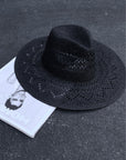black Straw woven fedora. Pinched crown. Wide brim. Inner drawstring closure. Unlined.