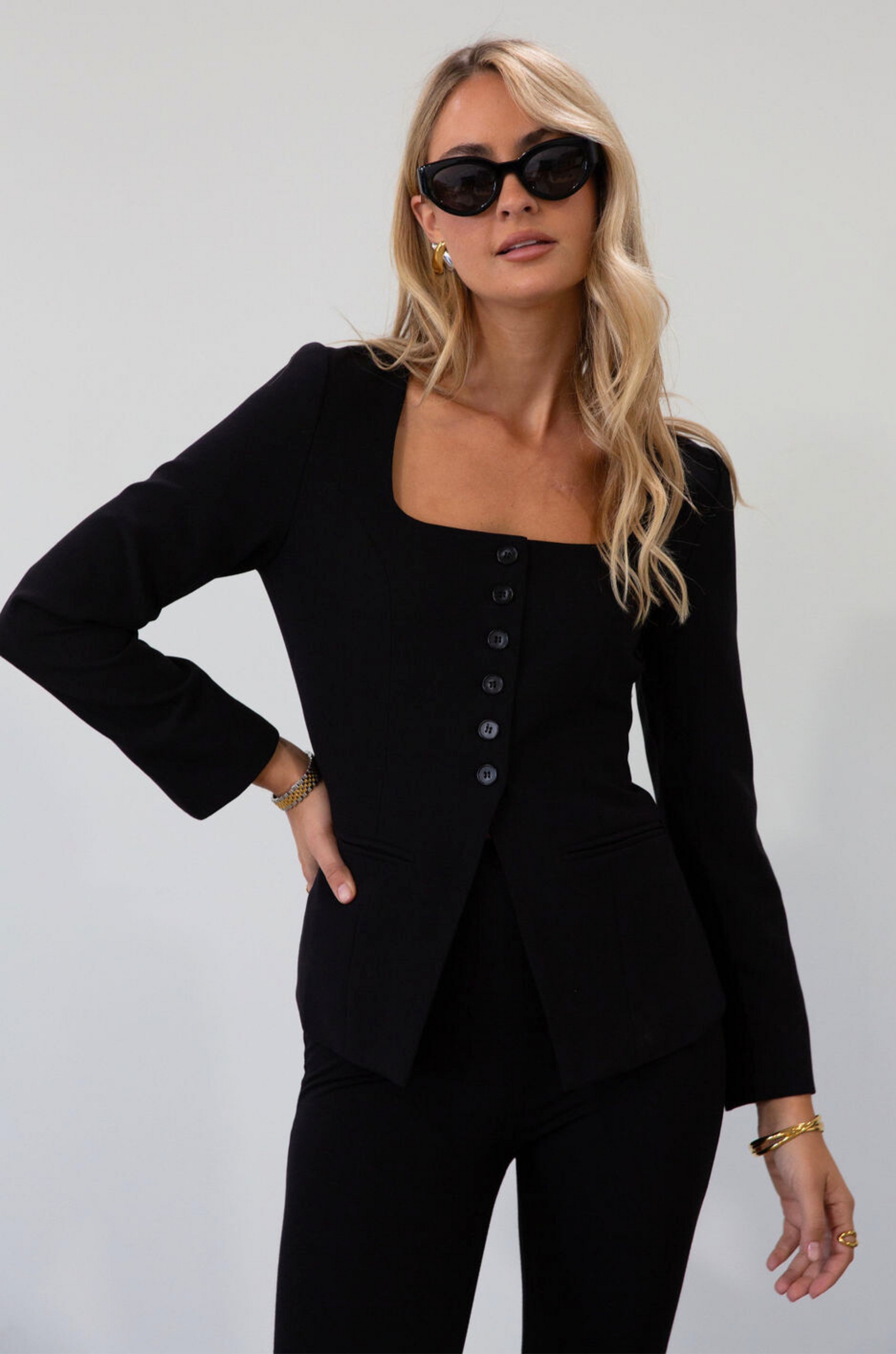 black Woven blazer style top. Long sleeves with faux button closures. Square neckline. Front button down closure. Faux front pockets. Fully lined. black fall top. work top