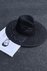 black Straw woven fedora. Pinched crown. Wide brim. Inner drawstring closure. Unlined.