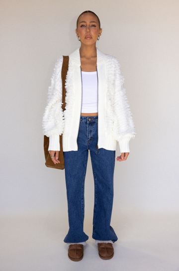 white Fringe crochet knit sweater
Front zipper closure
Long sleeves
Side pockets
Banded hems
Unlined