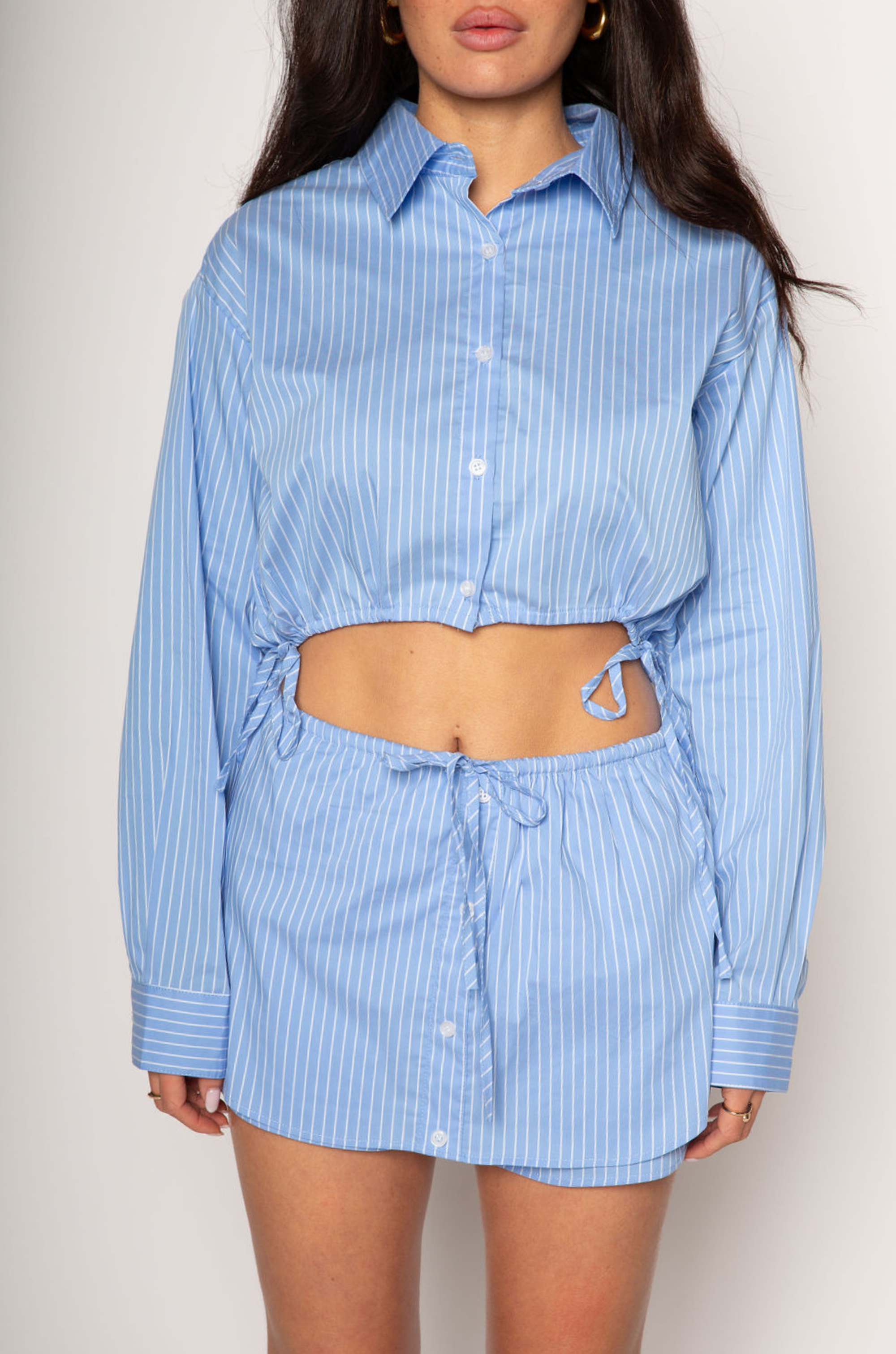 Striped woven skort. Elastic waistband with drawstring closure. Faux front button down closures. Shorts lining. blue stripe skort. blue stripe top skort