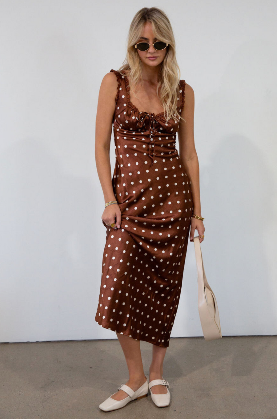 brown and white Polka dot printed satin maxi dress. Fixed straps. Lace trimmed neckline. Front drawstring closure. Side hook and eye and zipper closures. Back tie closure. Elastic back. Fully lined. fall dress. fall wedding guest dress. fall outfit