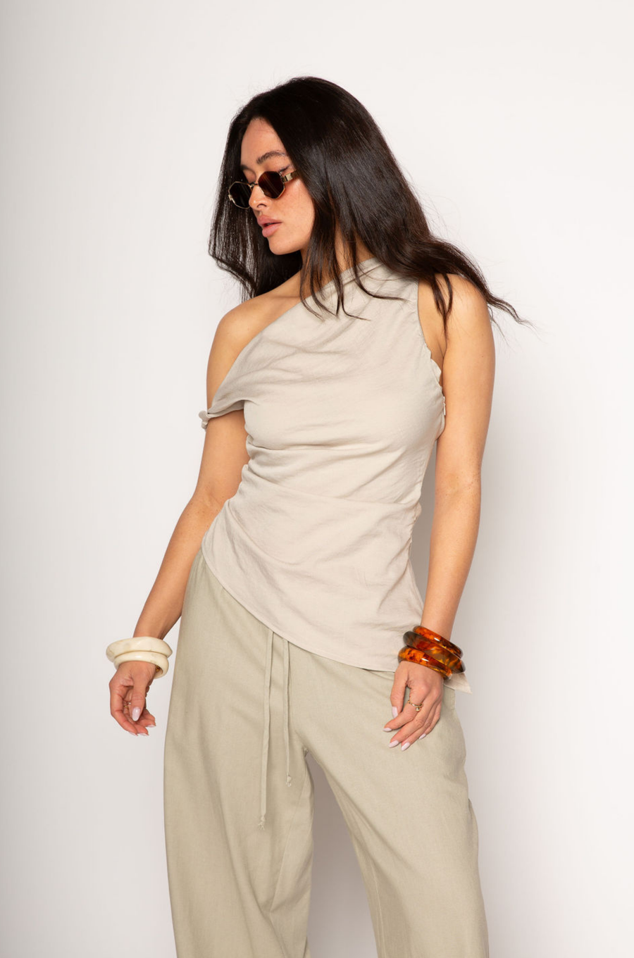 Woven top. Fixed straps. Twist strap. Ruched side. Asymmetric hem. Unlined. resort top. resort vacation top. resort outfit. asymmetrical top