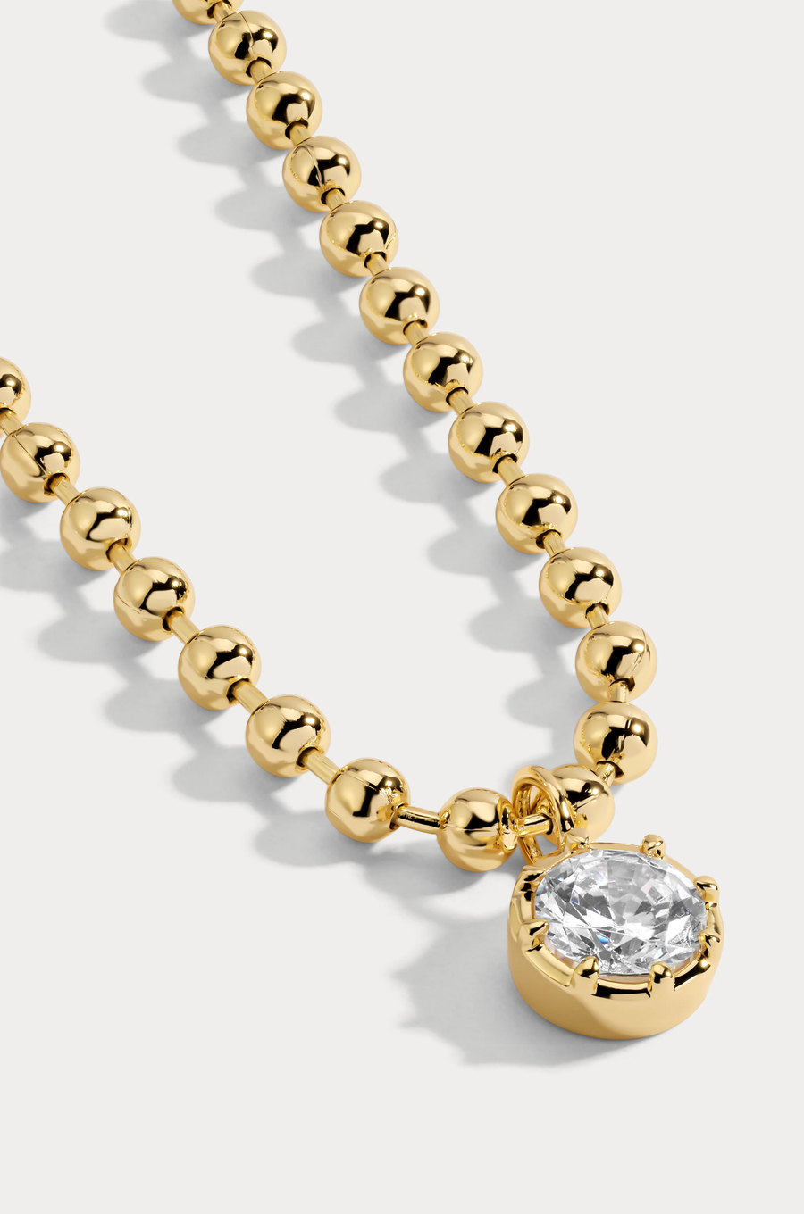 Delicate ball chain necklace anchored with a luminous CZ pendant
14kt gold plated brass&nbsp;or Rhodium plated brass
Stone is a white cz and measures 8.0mmNecklace measures 16" with a 3" extender
Lobster Clasp Closure
Gold chain necklace