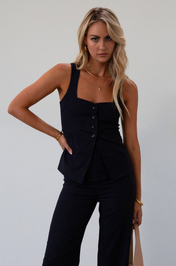 Plaid woven sleeveless top. Front button down closure. Faux front pockets. Adjustable back tie closure. Fully lined. navy blue blouse. work outfit. business casual outfit. 