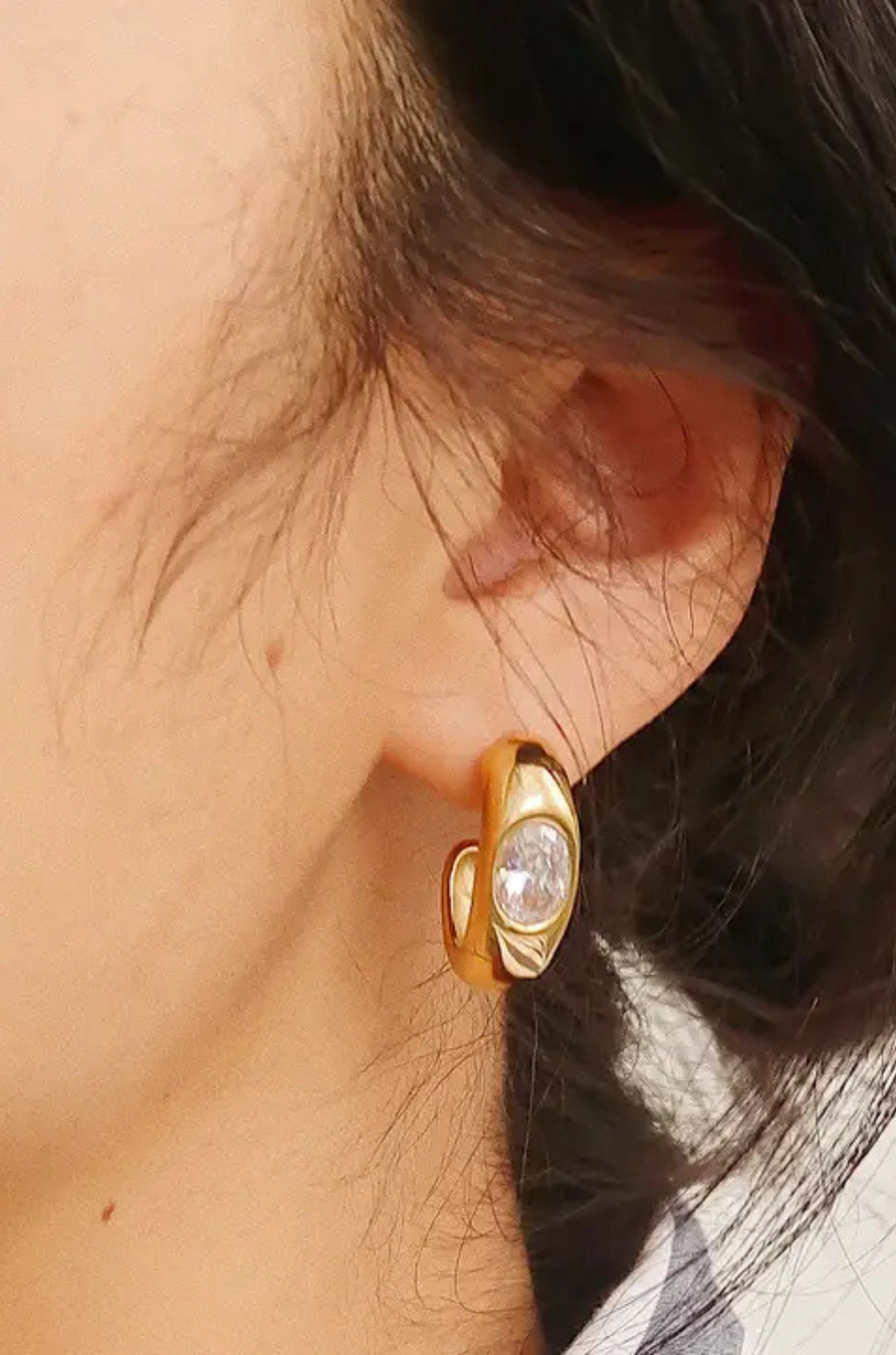 Gold earring with a clear gemstone worn by a person
18K Gold Non-Tarnish CZ Classic C Hoop Earring
18K Gold Plating
Stainless Steel
Cubic Zirconia (CZ)
Measurement (L x W inch): 0.8 x 0.7
Lead-free
Nickel-safe
Hypoallergenic
Water Resistant