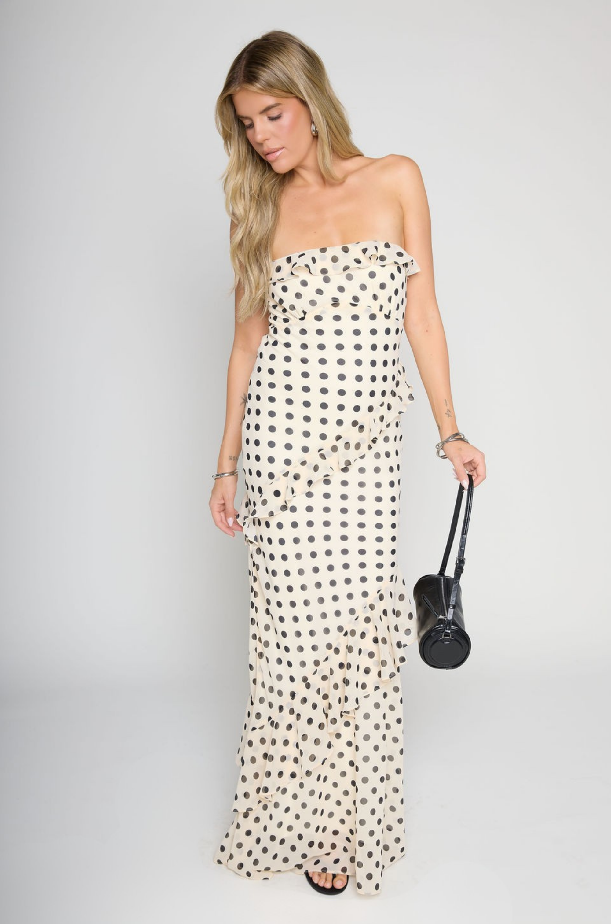 Polka dot printed maxi dress
Tube top
Ruffle on bust trim
Asymmetric ruffle detail on bottom half
Back cut out
Inner rubber grip lining
Side zipper closure
Lined
cream and black polka dot dress
bridal maxi dress