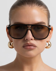 Modern aviator-inspired frame
Featuring a bold flat-top silhouette with geometric shaping
Navigator-inspired angular shaping
Oversized lens profile for full coverage
Polarisation: Category 3
UV Protection: UV400
Double bridge design
Keyhole cut-out detail between bridges
Slim arm design
Lens Height: 5.16cm / Temple Length: 14.5cm / Temple Tip Width: 10.5cm /
Nose Bridge: 1.8cm, Frame Width: 14.4cm