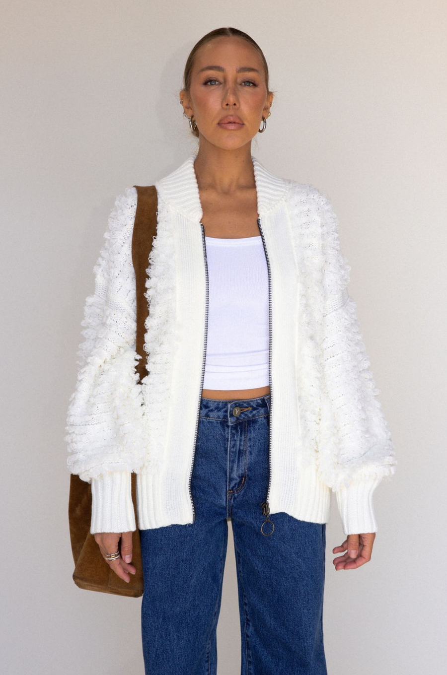 white Fringe crochet knit sweater
Front zipper closure
Long sleeves
Side pockets
Banded hems
Unlined
