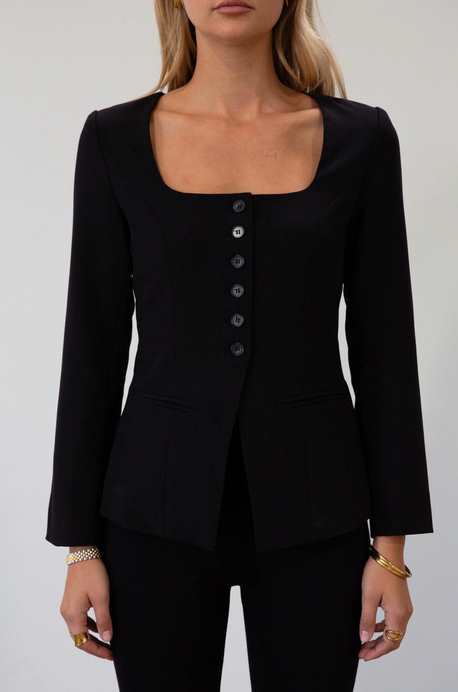 black Woven blazer style top. Long sleeves with faux button closures. Square neckline. Front button down closure. Faux front pockets. Fully lined. black fall top. work top