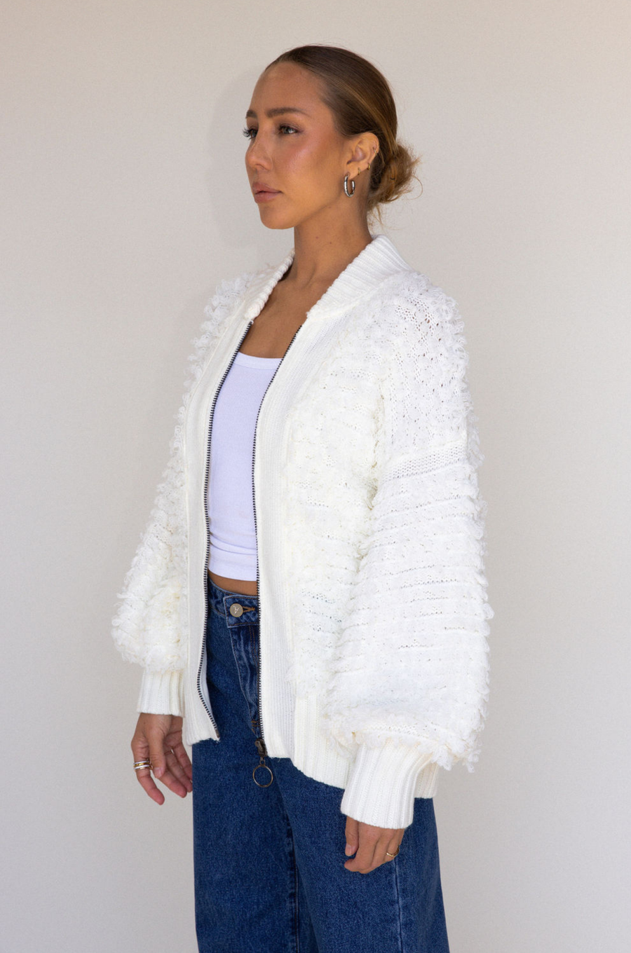 white Fringe crochet knit sweater
Front zipper closure
Long sleeves
Side pockets
Banded hems
Unlined