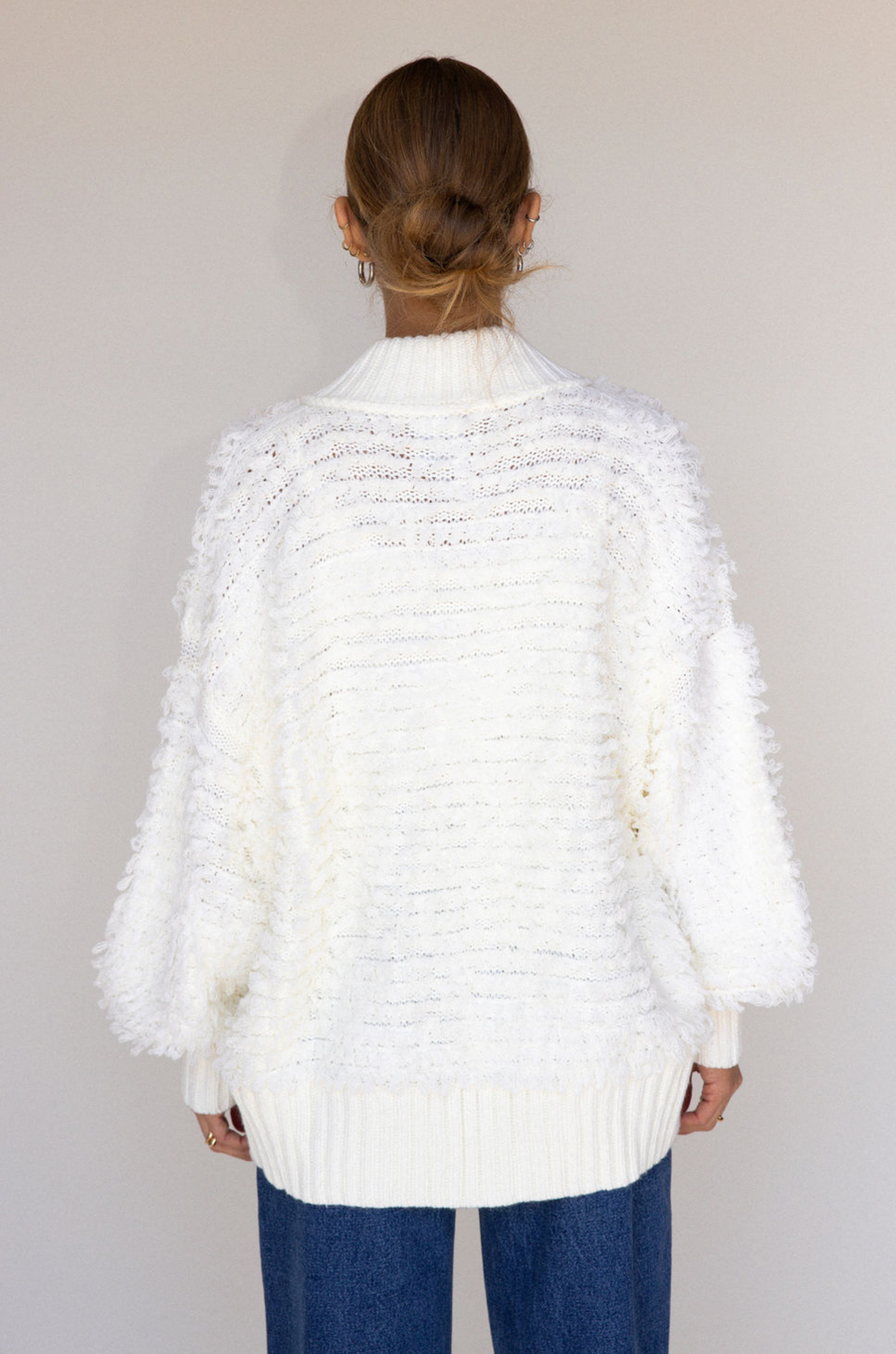 white Fringe crochet knit sweater
Front zipper closure
Long sleeves
Side pockets
Banded hems
Unlined