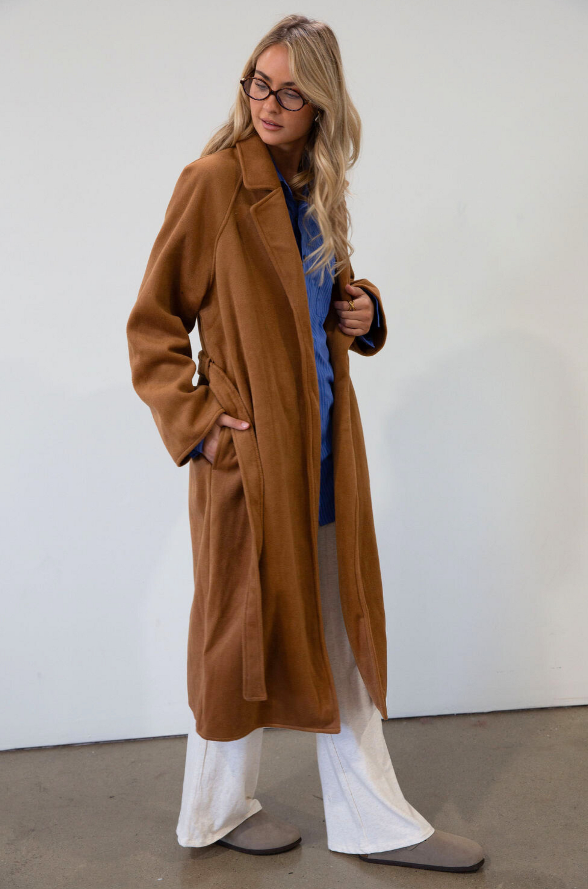 brown Vegan wool trench coat. Collar neckline. Long sleeves. Tie waist. Side pockets. Unlined. tan trench coat. fall outfit. fall jacket
