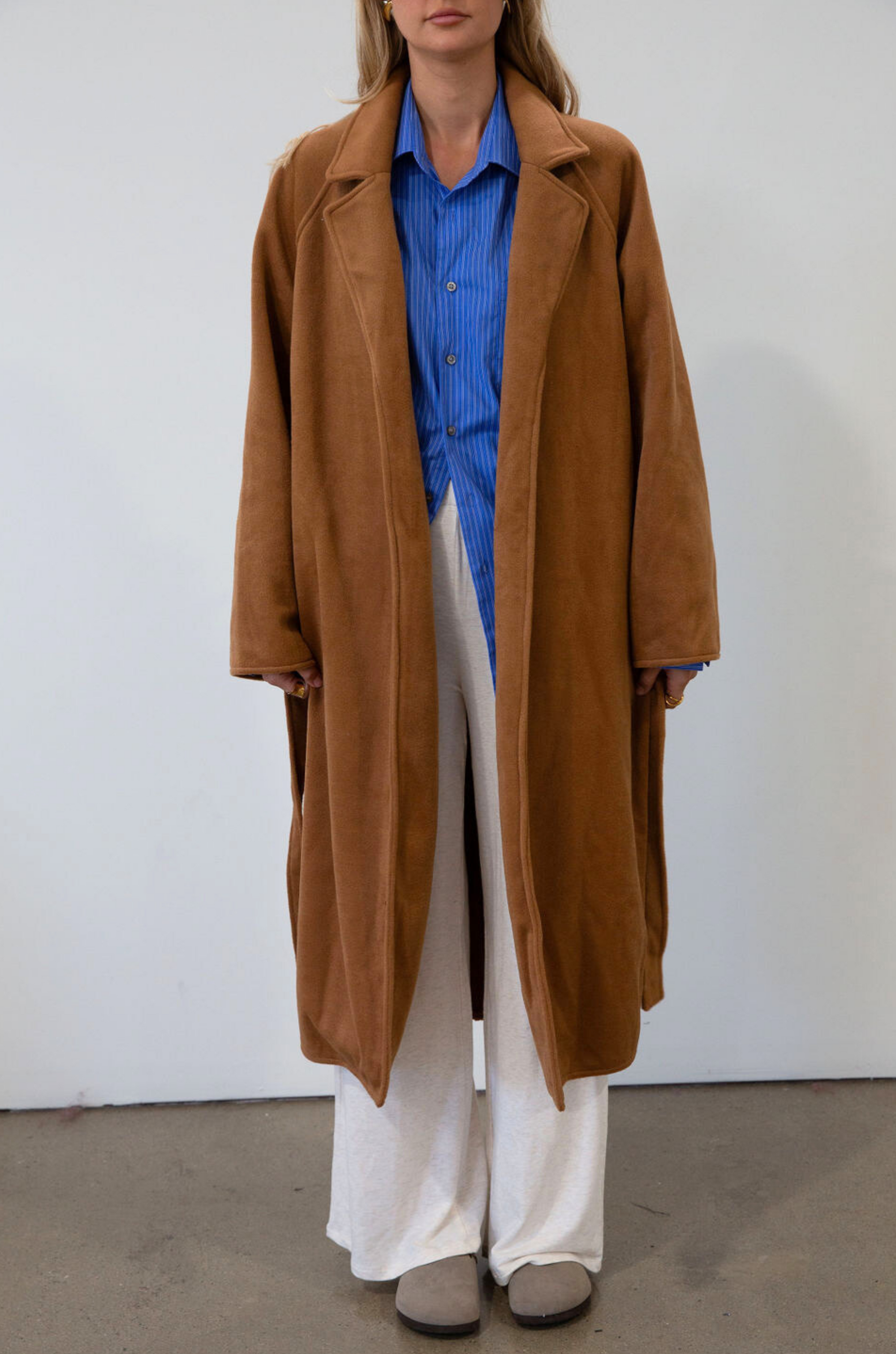 brown Vegan wool trench coat. Collar neckline. Long sleeves. Tie waist. Side pockets. Unlined. tan trench coat. fall outfit. fall jacket
