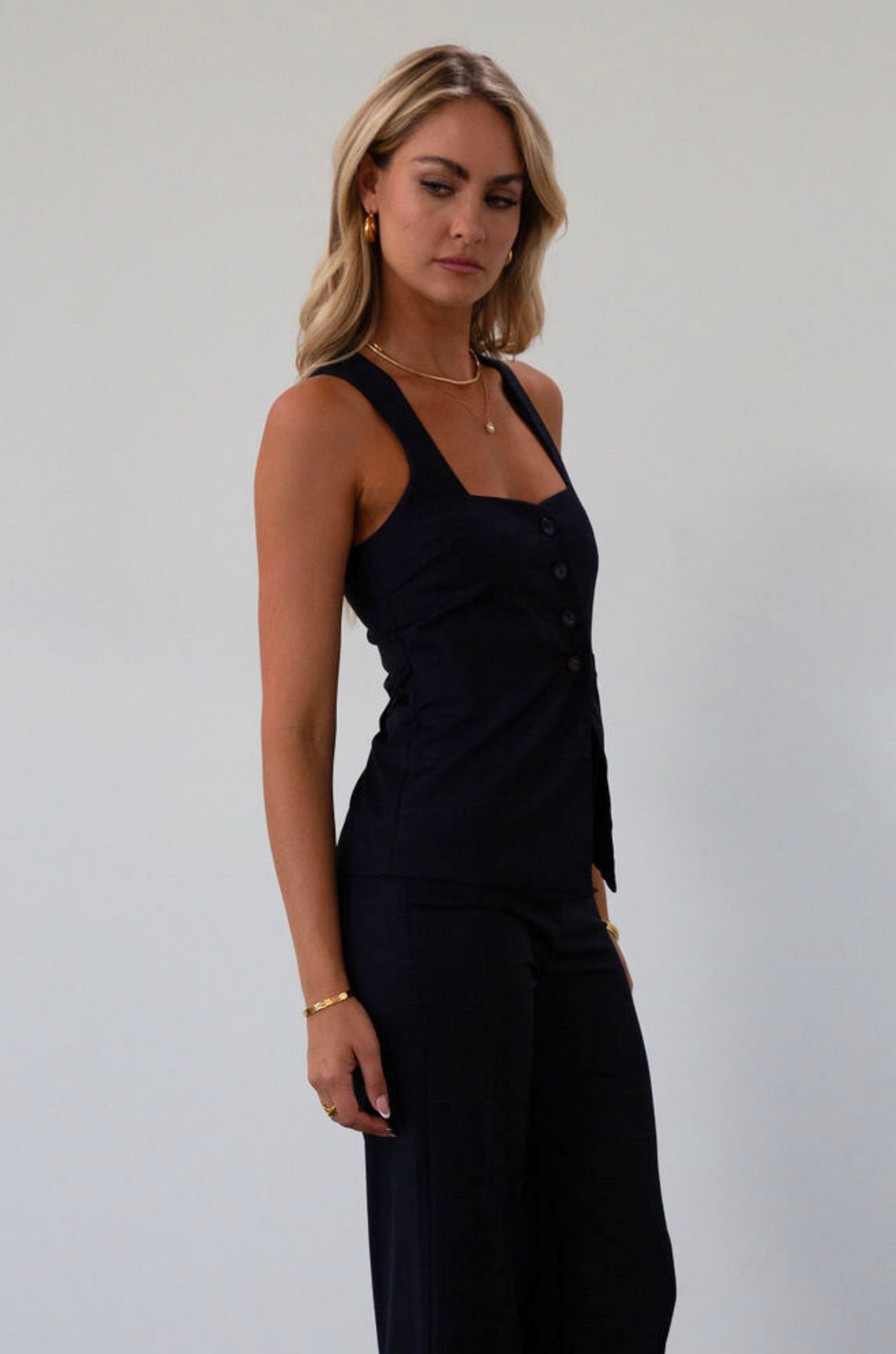 Plaid woven sleeveless top. Front button down closure. Faux front pockets. Adjustable back tie closure. Fully lined. navy blue blouse. work outfit. business casual outfit. 