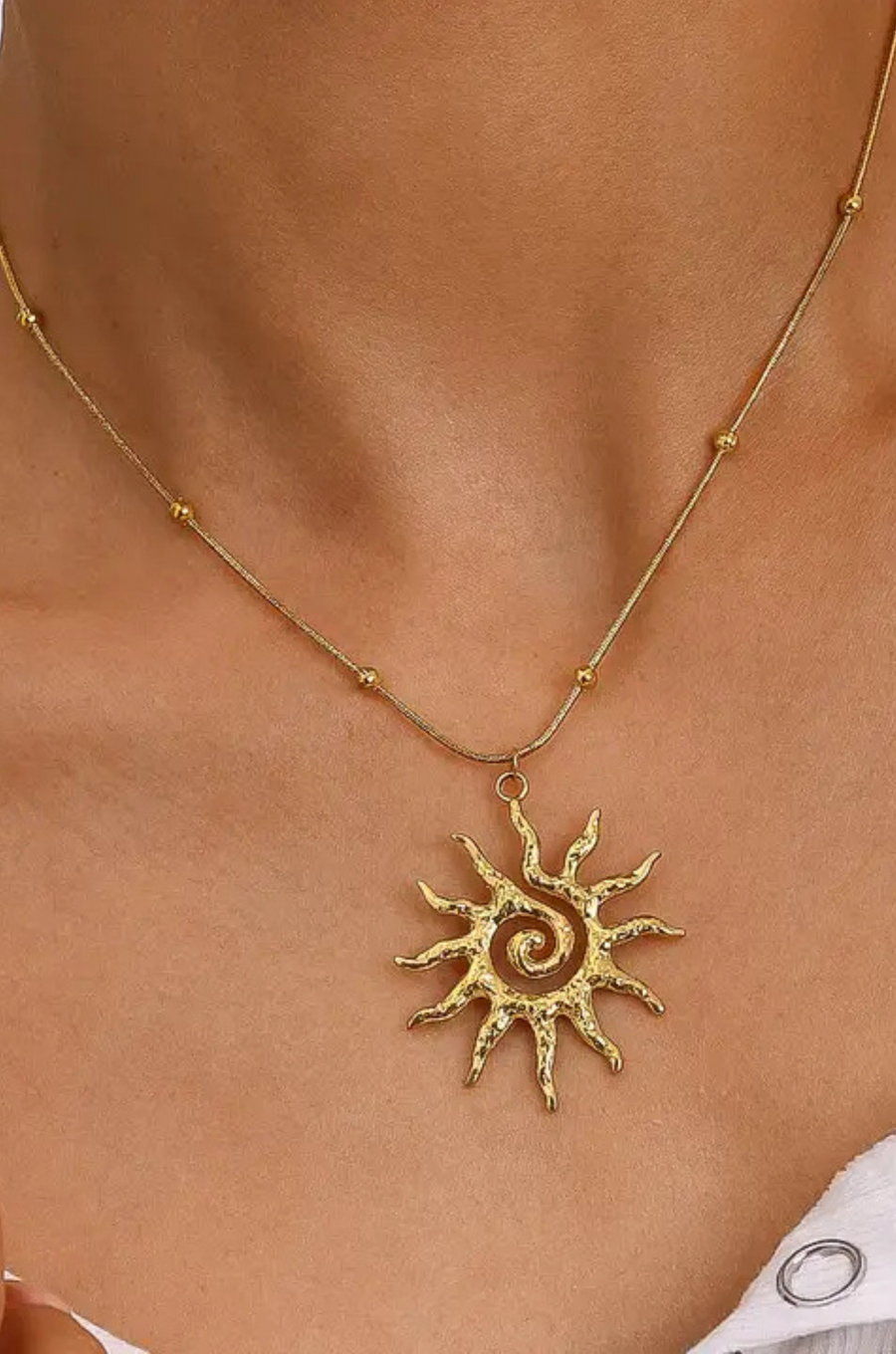 Gold necklace with a sun-shaped pendant
18K Gold Non-Tarnish Boho Sun Necklace
18K Gold Plated
Stainless Steel
Pendant Size: 1.5" / Chain Length: 15.57" / Extension Length: 2"
Lead-free
Nickel-safe
Hypoallergenic
Water Resistant