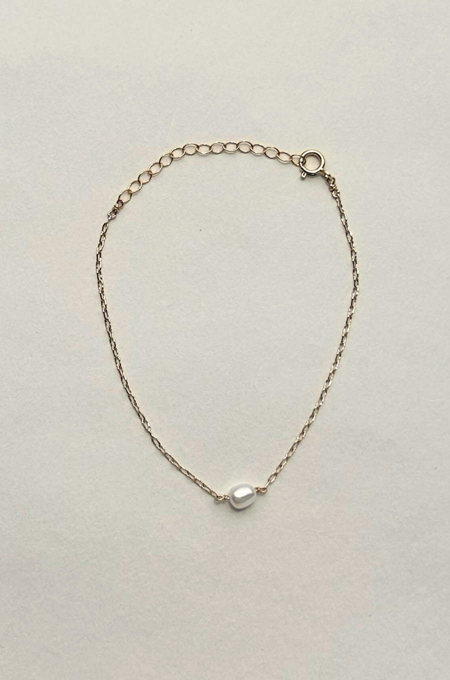 Gold filled dainty chain bracelet
Freshwater pearl charm
Length: 5" with a 1.5" extender
Freshwater pearl charm: .25"
Size and shape of pearl may vary