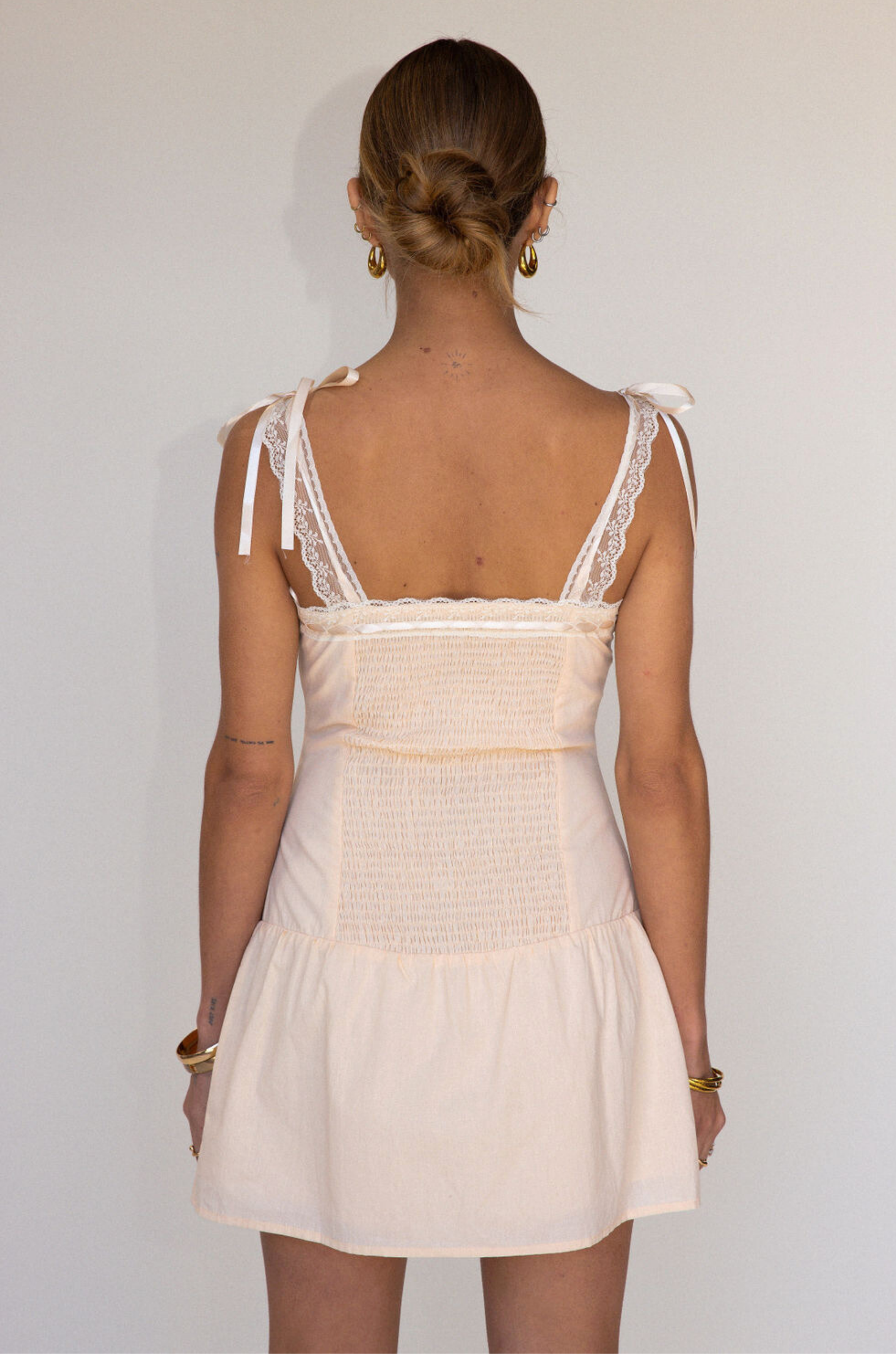 tan Woven coquette mini dress
Front bow detail
Front button closure
Adjustable lace and ribbon shoulder straps
Pintuck details on bodice
Smocked backing
Lined
summer mini dress
spring mini dress