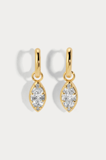 A charmed hoop featuring our most loved marquise cut that catches light with every move
Available in 14kt gold plated brass or Rhodium plated brass
Stones are white cz and measure 10mm x 5.0mm each
Snap Hinge Closure
Sold as a pair
gold cz earrings
fake diamond earrings
