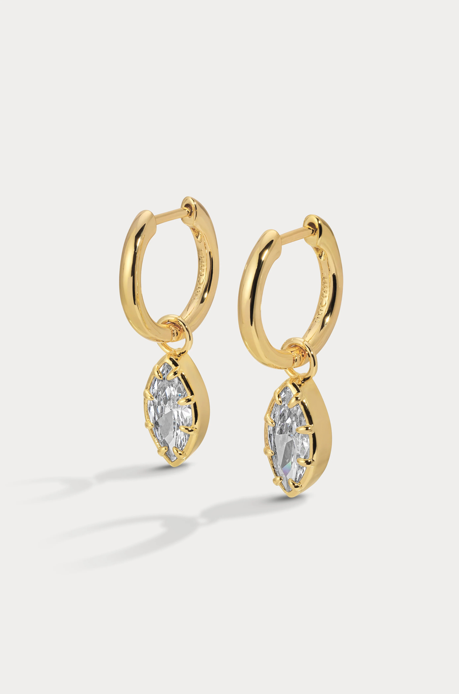 A charmed hoop featuring our most loved marquise cut that catches light with every move
Available in 14kt gold plated brass or Rhodium plated brass
Stones are white cz and measure 10mm x 5.0mm each
Snap Hinge Closure
Sold as a pair
gold cz earrings
fake diamond earrings