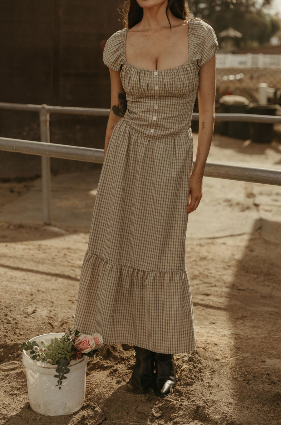 Checkered printed woven maxi dress. Elastic neckline. Short sleeves with elastic openings. Faux front button closures. Back hook and eye and zipper closures. Partially lined. plaid maxi dress. western outfit. ranch outfit. country dress