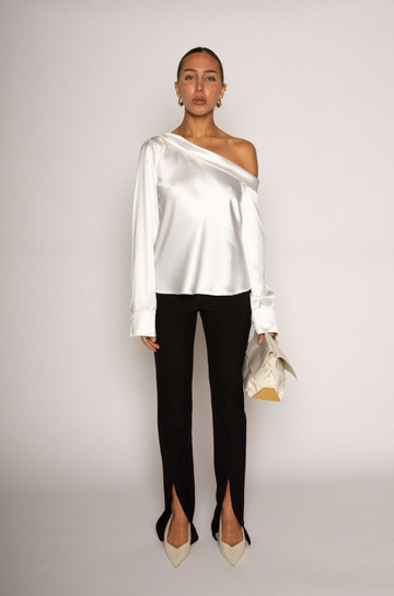 white Satin top. Folded off the shoulder neckline. Long sleeves with button closures. Unlined. white satin one shoulder top. 