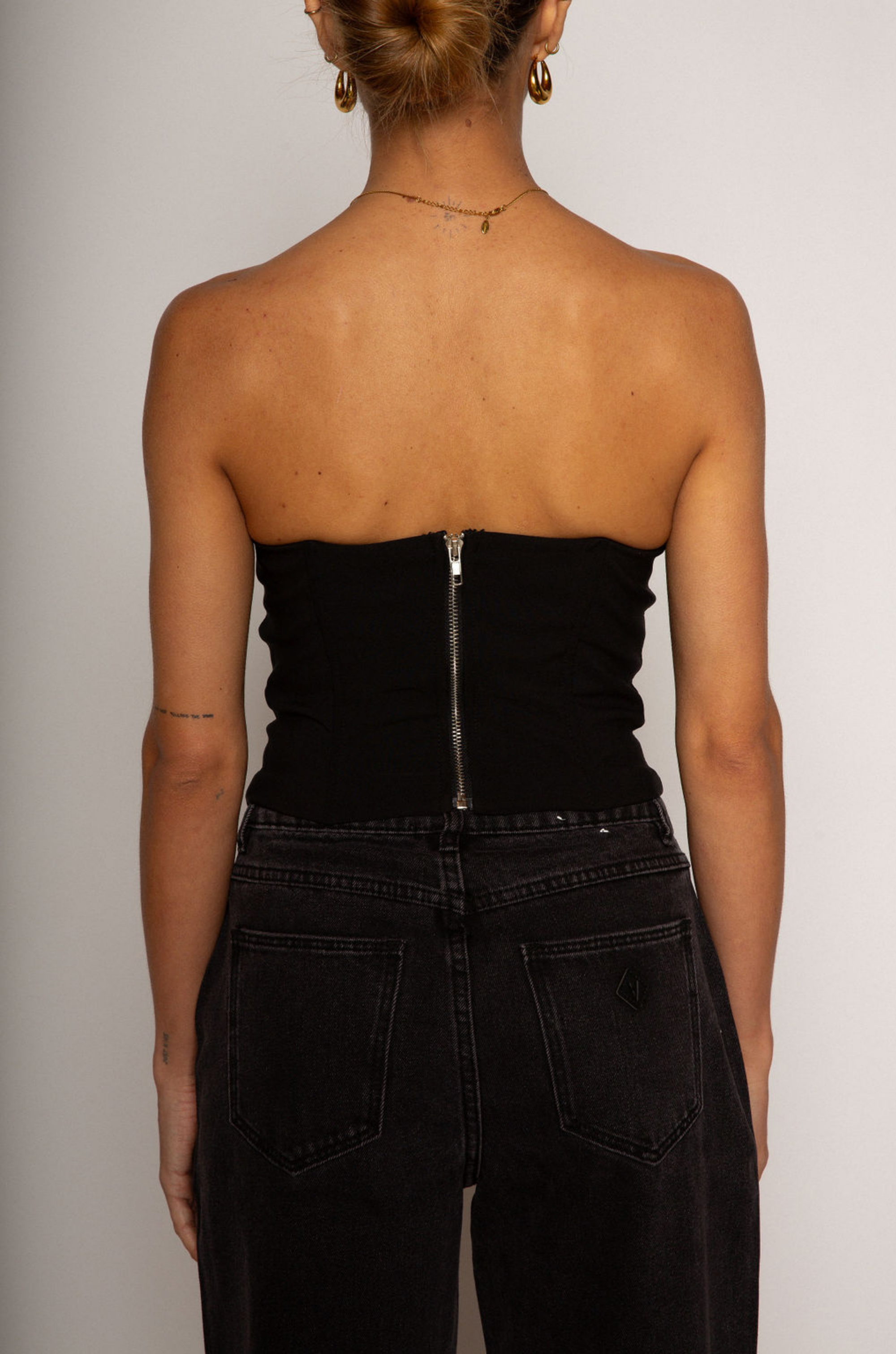 Color blocked woven bustier. Strapless neckline with inner rubber grip lining. Boning in bodice. Back hook and eye and zipper closures. Fully lined. black corset. going out top