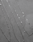 Three separate thin chain belly chains. Small bead and teardrop embellishments. Adjustable lobster clasp closures.
layered silver belly chain