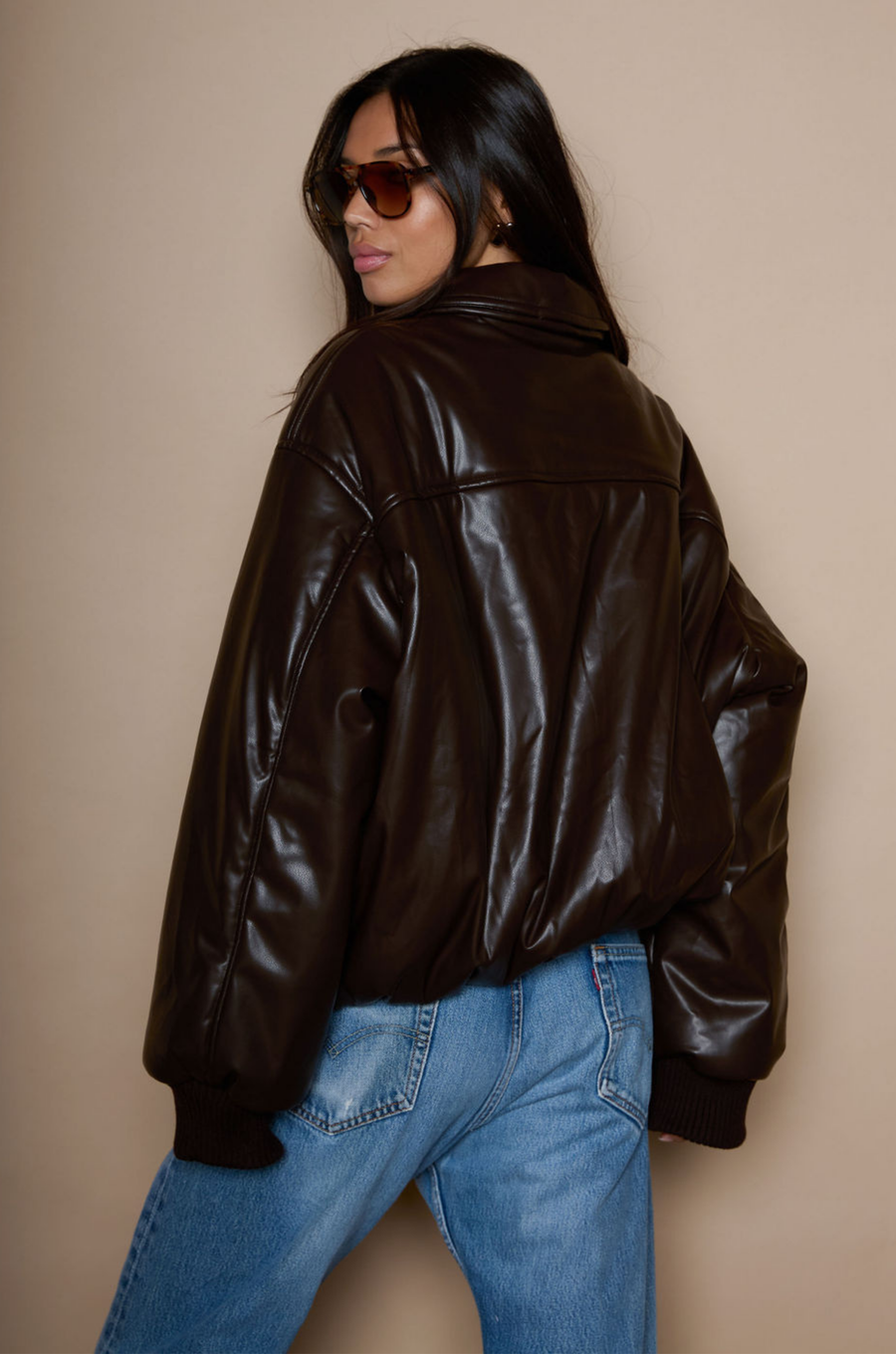 Faux leather jacket. Collar neckline. Long sleeves with elastic openings. Front zipper closures. Side pockets with snap button closure. Elastic hem. Fully lined. brown puffer jacket. brown puffer bomber jacket. fall jacket. bomber jacket. going out jacket