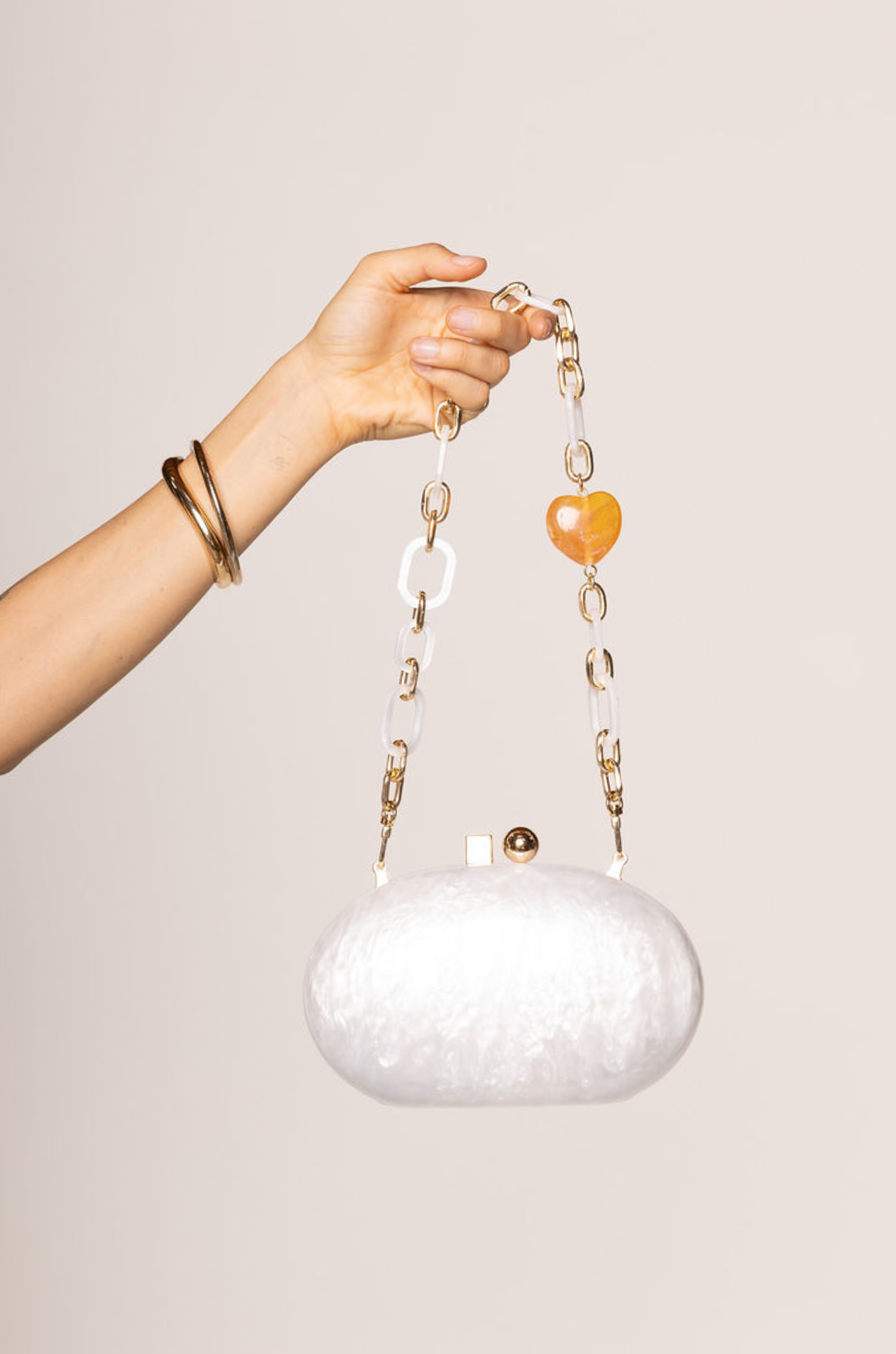 ivory Hardshell marble clutch
Magnetic closure
Acrylic chain straps with heart detail
Removable long and short chain
Synthetic