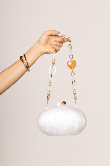 ivory Hardshell marble clutch
Magnetic closure
Acrylic chain straps with heart detail
Removable long and short chain
Synthetic