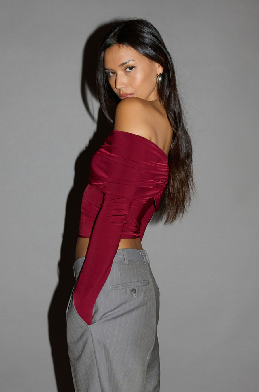 Knit crop top. Strapless elastic folded neckline. Front and back ruching. Long sleeves. Unlined. red off the shoulder long sleeve top. burgundy off the shoulder long sleeve top. holiday outfit. holiday look. christmas top. christmas outfit