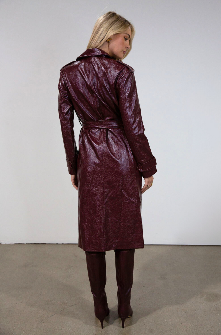 Faux leather trench coat. Collar neckline. Double breasted. Front button closures. Belted waist. Side pockets. Fully lined. burgundy faux leather trench coat. fall outfit. fall trench coat