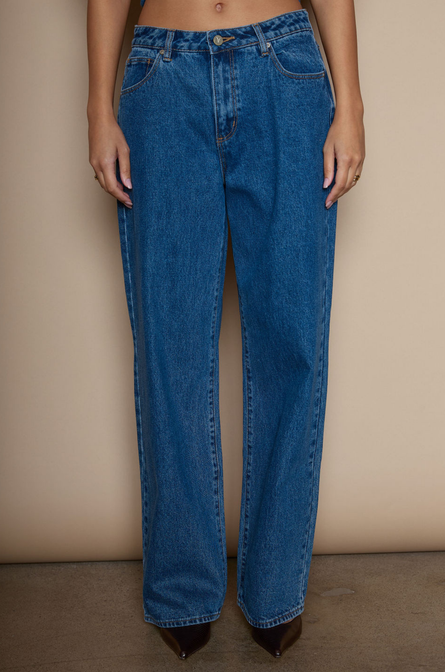 Mid rise straight leg jeans. Relaxed fit. Button and zipper fly. Five pocket construction. medium wash denim jeans