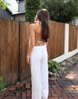 white Woven embroidered eyelet top
Lace detailing
Adjustable halter neck tie
Adjustable back tie
Unlined/Partially sheer
Open back
