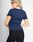 Graphic printed elastic smocked crop top. V-neckline. Short sleeves. Contrast detailing. navy tee. lioness scrunched graphic tee