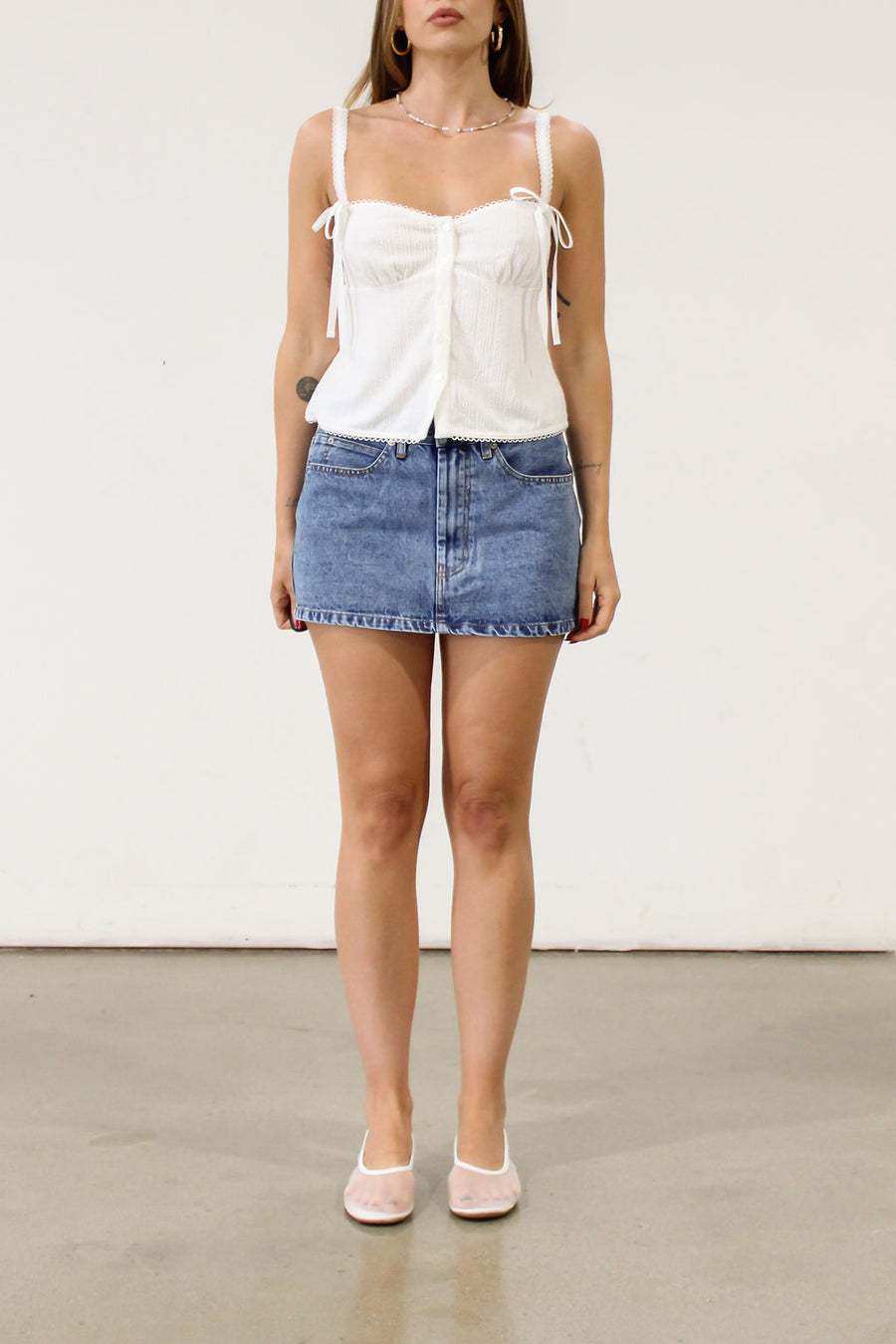 Denim skirt. Hook and eye and zipper fly. Five pocket construction. Unlined.Mini skirt. Denim mini skirt