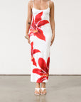 Floral printed knit maxi dress. Adjustable straps. Back slit. Fully lined. White maxi dress with crimson lily print.