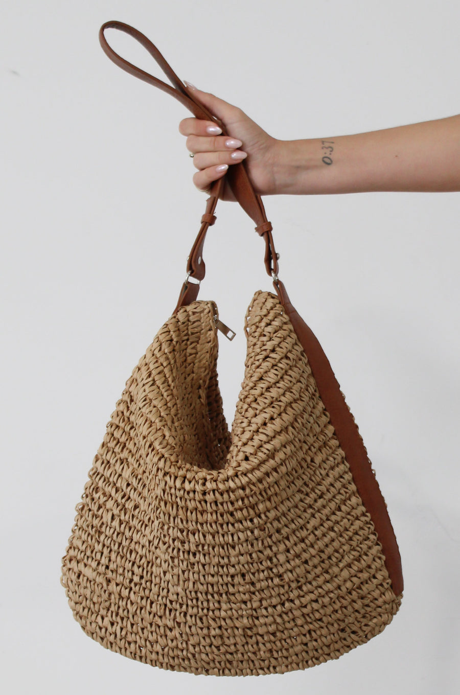 Straw woven bag. Vegan leather adjustable strap. Top zipper closure. Inner pockets. Fully lined.&nbsp;