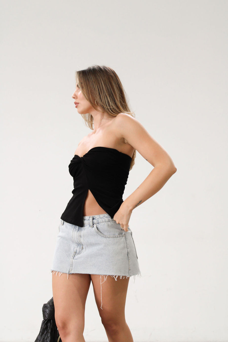 Knit Tube top. Elastic strapless neckline. Inner rubber grip lining. Ruched sides. Front slit. Unlined. Black tube top. 